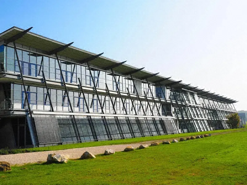 Modern office building with a long, evenly mowed lawn along its front walkway